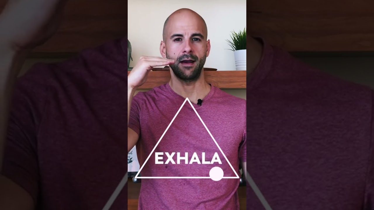 Meditación & Mindfulness Un hombre que practica meditación y atención plena sostiene un triángulo con la palabra exhala.